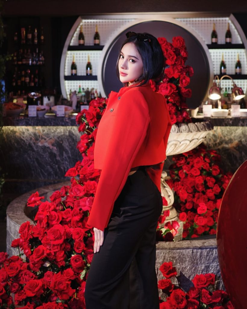 Potret close-up Anya Geraldine di Seoul dengan latar bunga mawar merah, mengenakan makeup flawless dan rambut bob sleek.