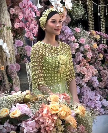 Dalam prosesi siraman, Alyssa memilih tatanan rambut tergerai, dihiasi dengan headpiece dari roncean melati, menciptakan tampilan yang elegan dan khas.