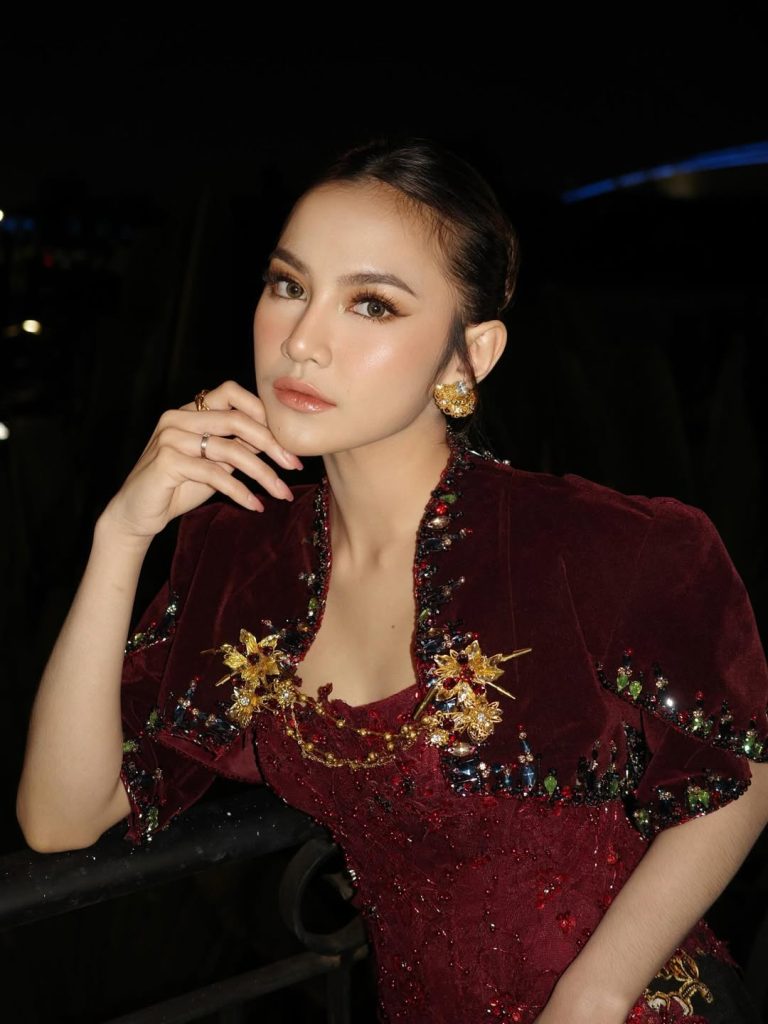 Tampilan kebaya Mahalini terdiri dari atasan brokat merah marun berdetail payet, yang menyatu apik dengan rok batik hitam bermotif bordir emas dan merah.