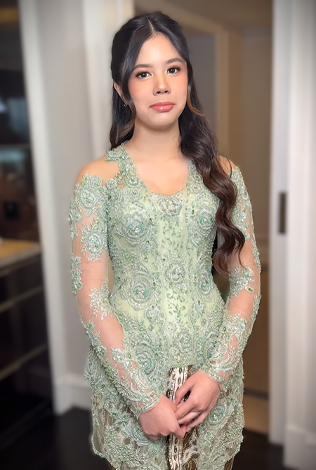 Kebaya model kutu baru tersebut memiliki potongan panjang hingga paha, terbuat dari bahan brokat transparan dengan detail bordir dan payet floral
