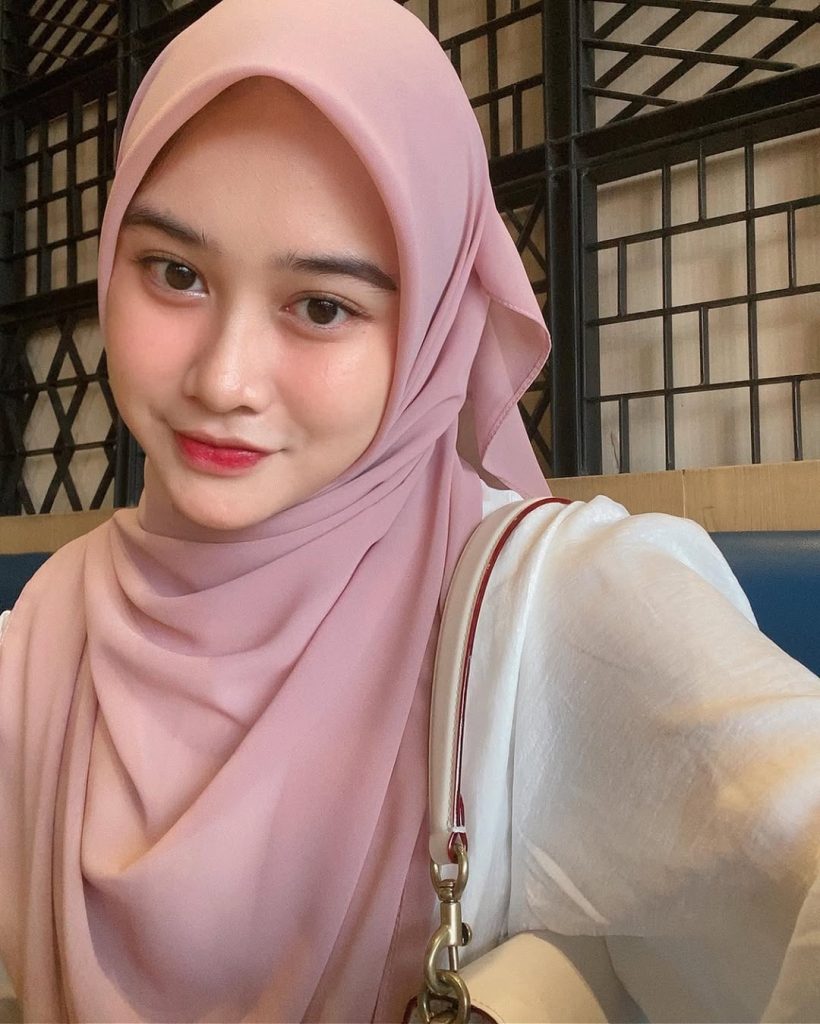 Potret close-up Khansa Mariska dengan ekspresi cute mengenakan hijab dan blouse satin putih.