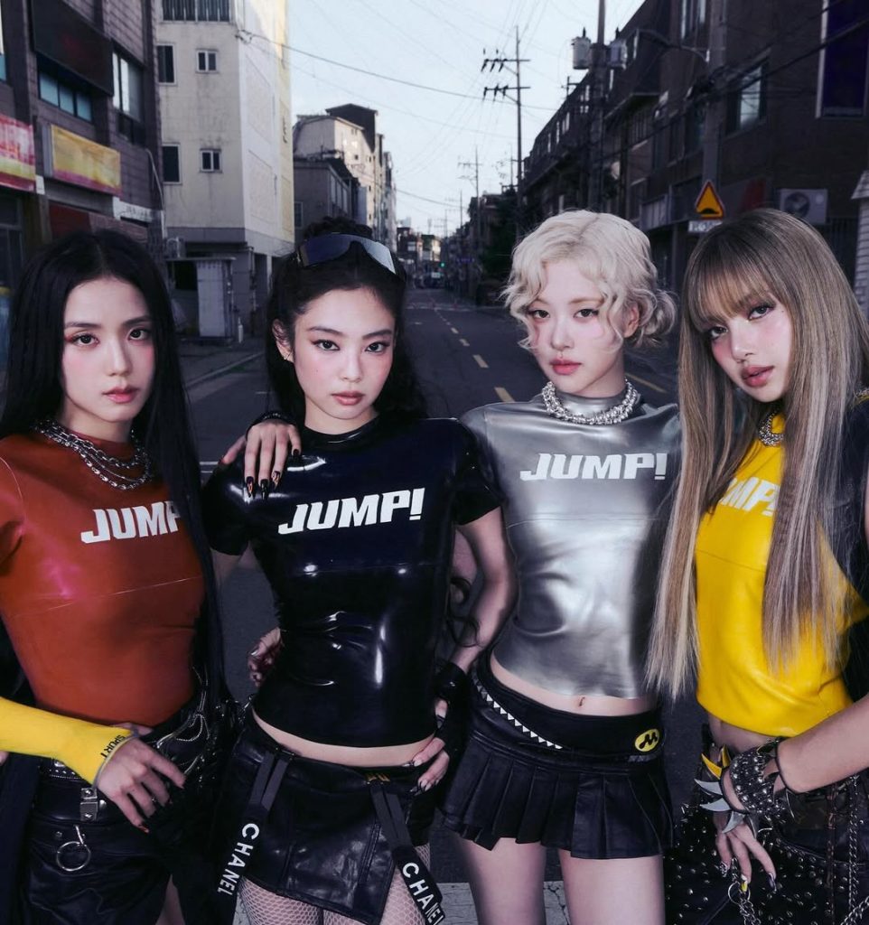 BLACKPINK tampil penuh gaya dalam visual video klip Jump, mengenakan pakaian futuristik dengan latar grafis dinamis dan pencahayaan neon.