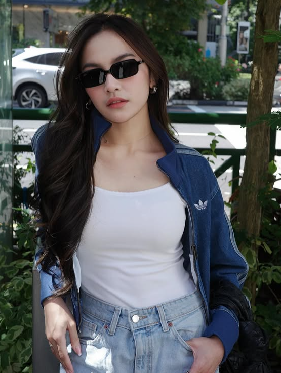 Mahalini juga menunjukkan sisi sporty-nya dengan mengenakan jaket denim dari Adidas Originals Adicolor 90’s yang dipadukan dengan tank top putih dan celana jeans.