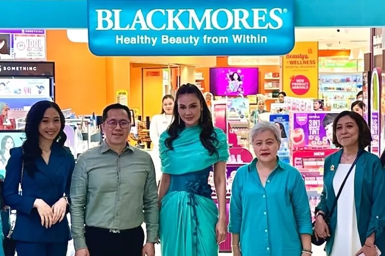 Luna Maya berdiri di panggung peluncuran Blackmores Ultimate Vibrant Skin, mengenakan busana putih elegan dengan latar backdrop bertema “Healthy Beauty from Within”, mencerminkan citra kulit sehat dan gaya hidup aktif.