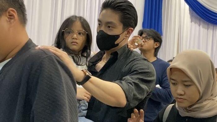 Giorgio Antonio mengenakan pakaian serba hitam menggendong Thania Putri Onsu di rumah duka Grand Heaven, memperlihatkan kedekatan dan dukungan emosional di tengah prosesi Malam Kembang.