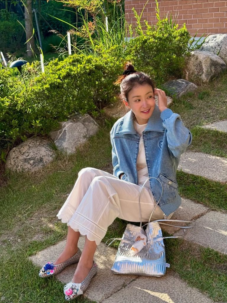 Lee Si Young tampil memukau dengan kombinasi jaket denim oversized dan celana putih beraksen scallop di bagian bawah.
