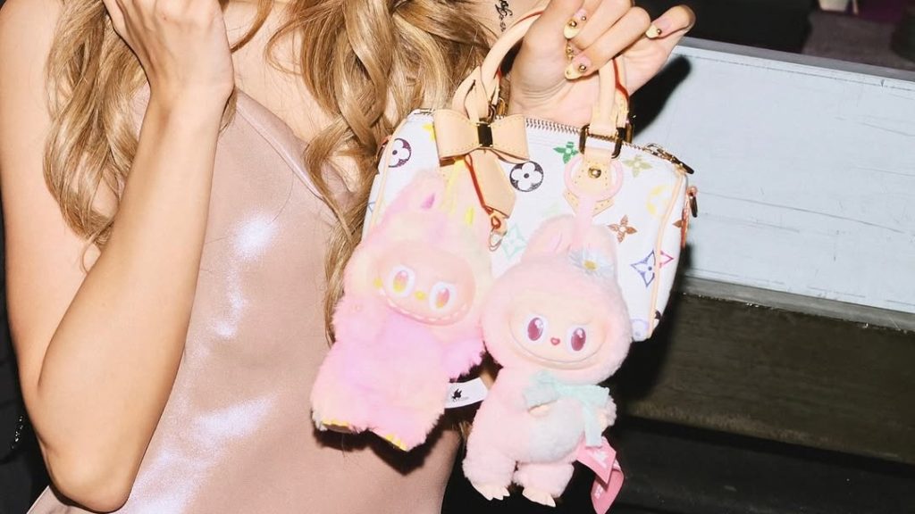 Tampilan close-up tas Nano Speedy monogram pelangi milik Lisa dengan gantungan Labubu oversized, memperlihatkan kombinasi fashion luxury dan pop culture.