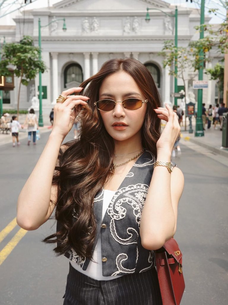 Mahalini terlihat mengenakan tank top putih polos yang dipadukan dengan vest abu-abu gelap bermotif paisley bordir putih. Gaya ini memberikan kesan clean namun tetap artistik.