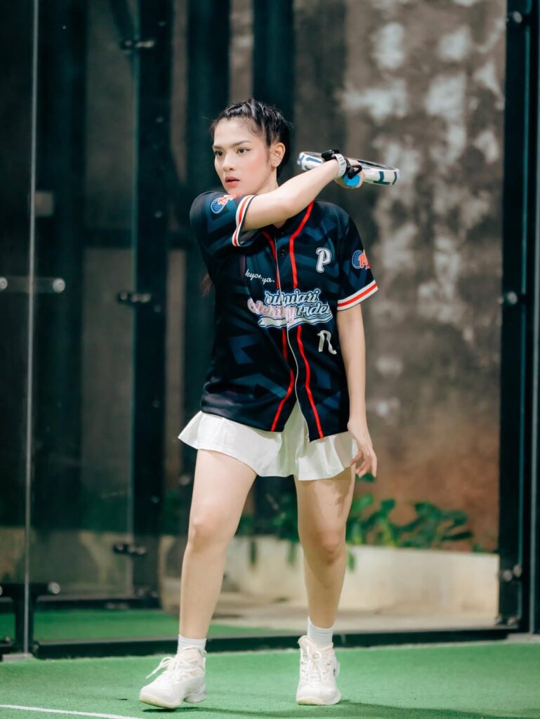 Davina Karamoy mengenakan jersey hitam sporty saat bermain padel