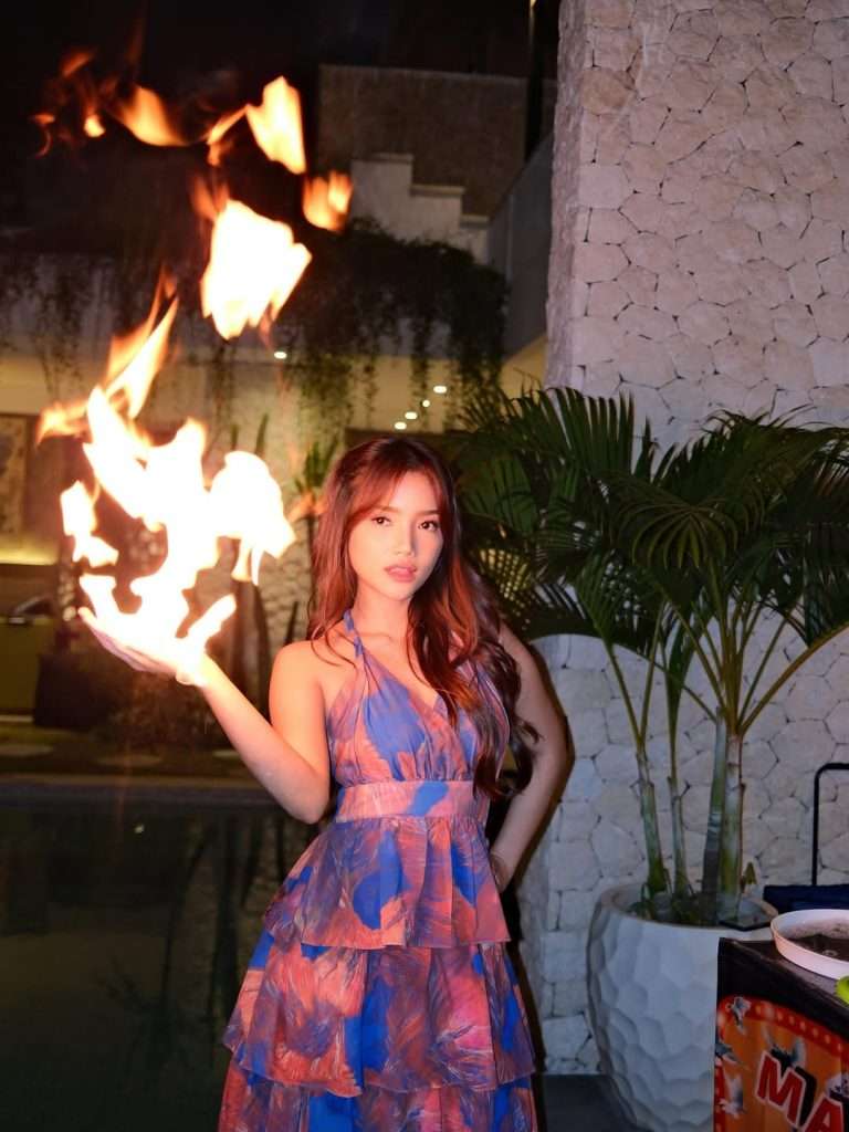 Potret close-up Fuji An memegang api dengan ekspresi percaya diri dan tenang