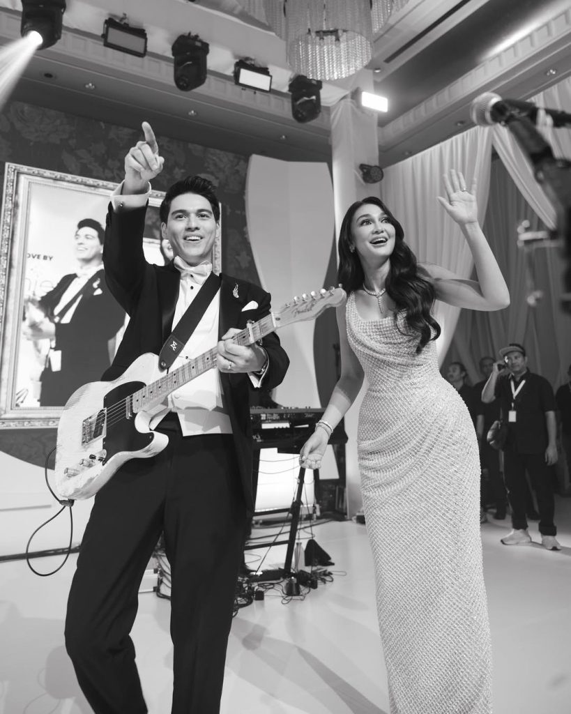 Luna Maya dan Maxime Bouttier berdiri di tengah venue resepsi bertema “Sun and Moon”, mengenakan busana monokrom elegan.