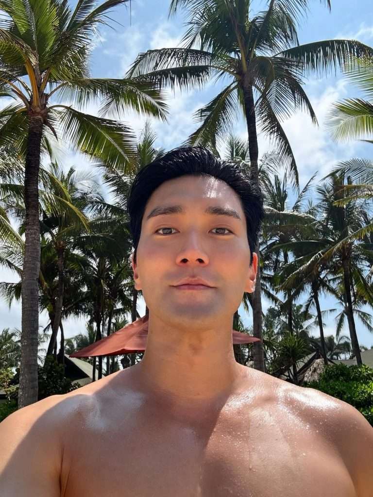 Dalam salah satu potret yang dibagikan, Siwon terlihat berjemur di tepi pantai dengan latar langit cerah dan pepohonan kelapa.