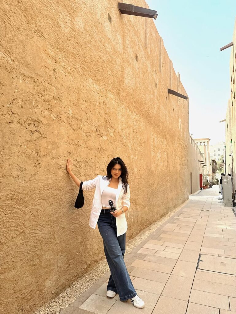 Davina mengenakan tanktop putih yang dipadukan dengan celana jeans biru dan kemeja putih lengan panjang yang digulung setengah.