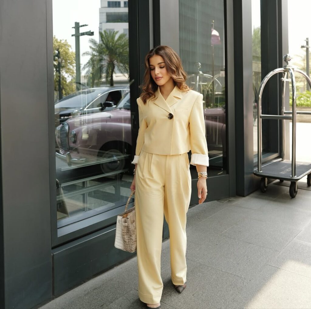 Tasya mengenakan setelan dari label Ganni yang terdiri dari cropped blazer dan celana relaxed fit. Warna kuning pastel yang dipilih bukan tanpa makna.