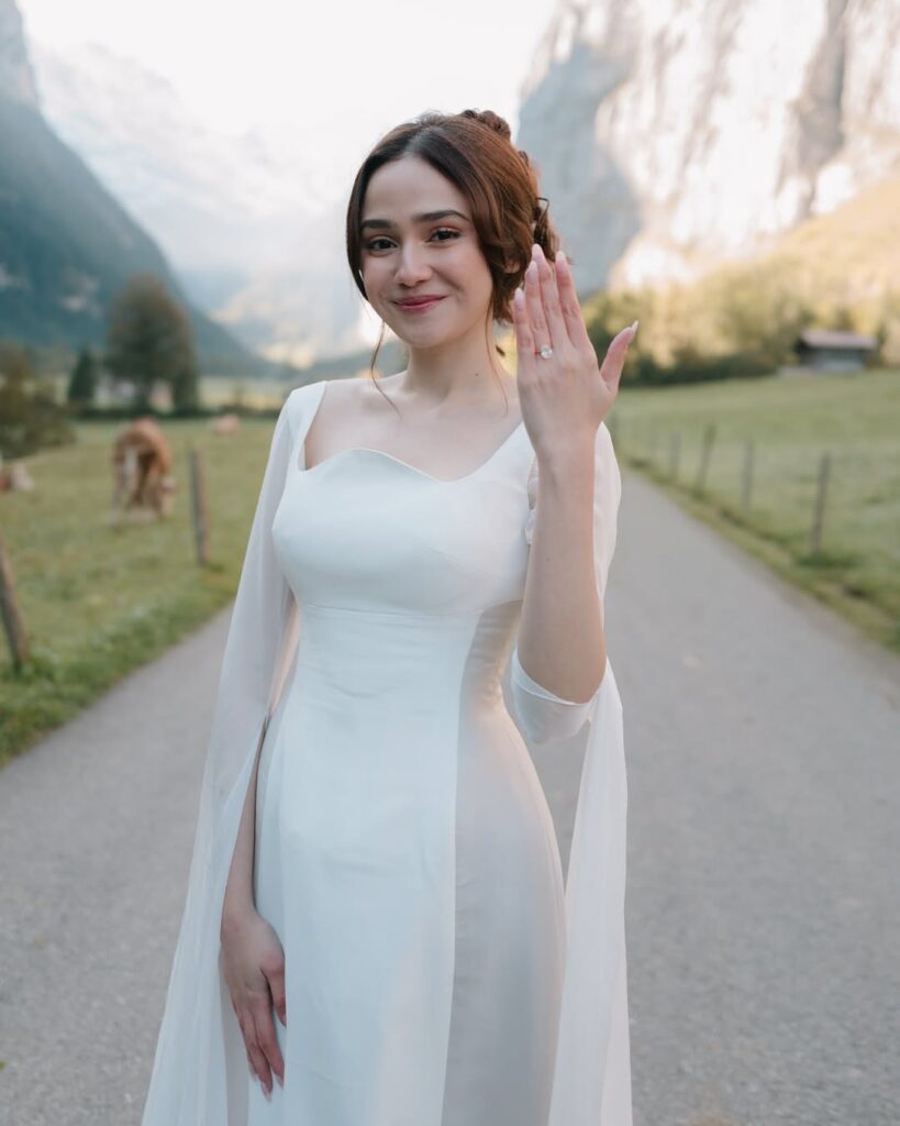 Gaun lamaran Syifa Hadju memiliki potongan siluet fit yang mengikuti lekuk tubuhnya secara anggun, menciptakan tampilan yang memesona tanpa kesan berlebihan.