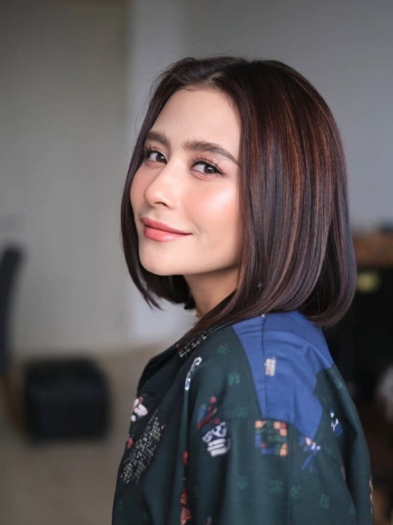 Prilly memilih potongan bob pendek dengan belahan tengah yang memberi kesan tegas sekaligus feminin.