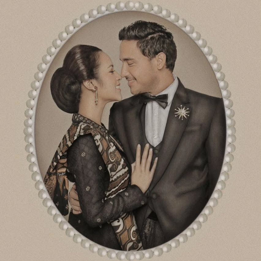 Raisa dan Hamish Daud berbusana adat klasik dalam potret elegan bernuansa tradisional.