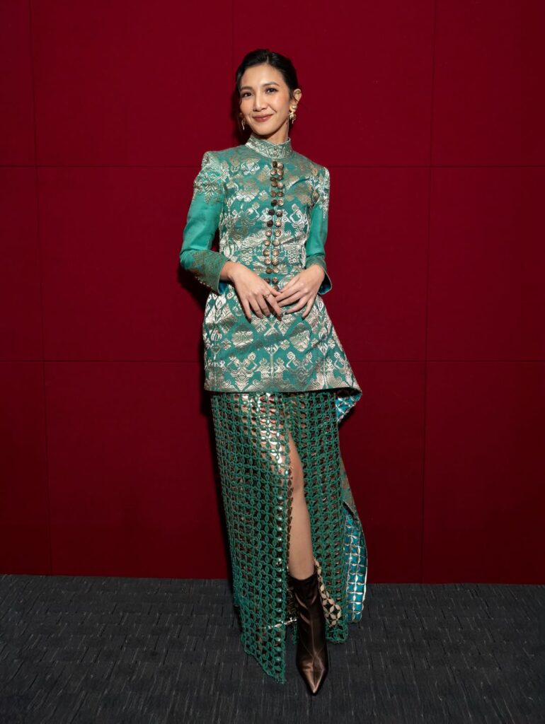 Kombinasi ini semakin dramatis dengan pilihan sepatu boot metalik berujung runcing, menambah kesan edgy 