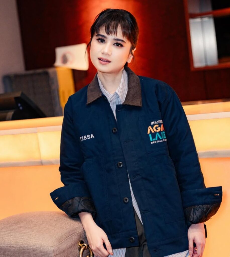 Tissa memadukan poni barunya dengan gaya rambut low updo yang sleek namun natural.