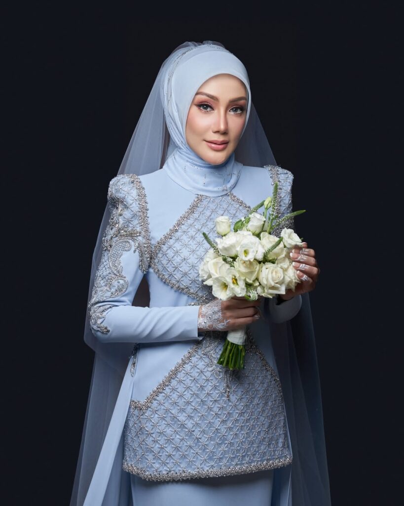 Di hari bahagianya, Erra tampil anggun mengenakan gaun biru muda rancangan desainer lokal.