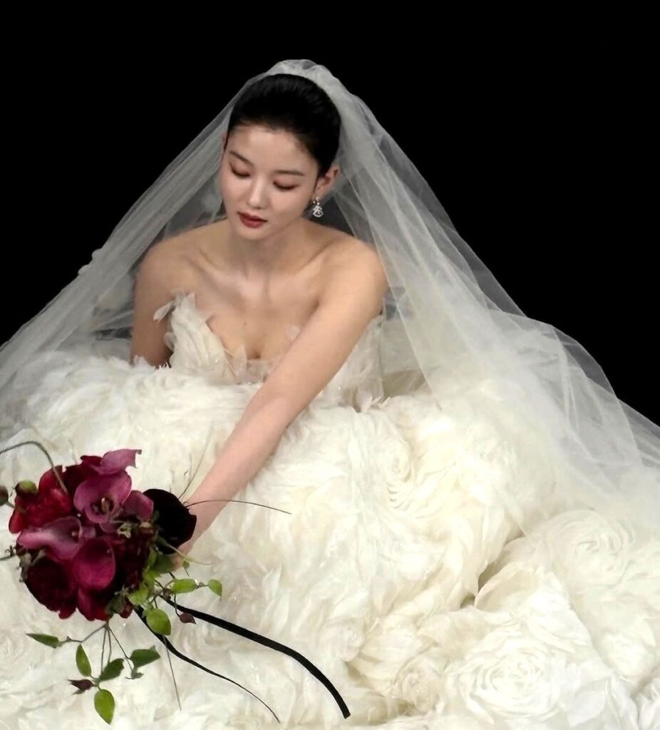 Kim Yoo Jung tampil dalam beberapa gaya gaun pengantin, mulai dari klasik putih dengan veil hingga gaun hitam off-shoulder yang elegan.