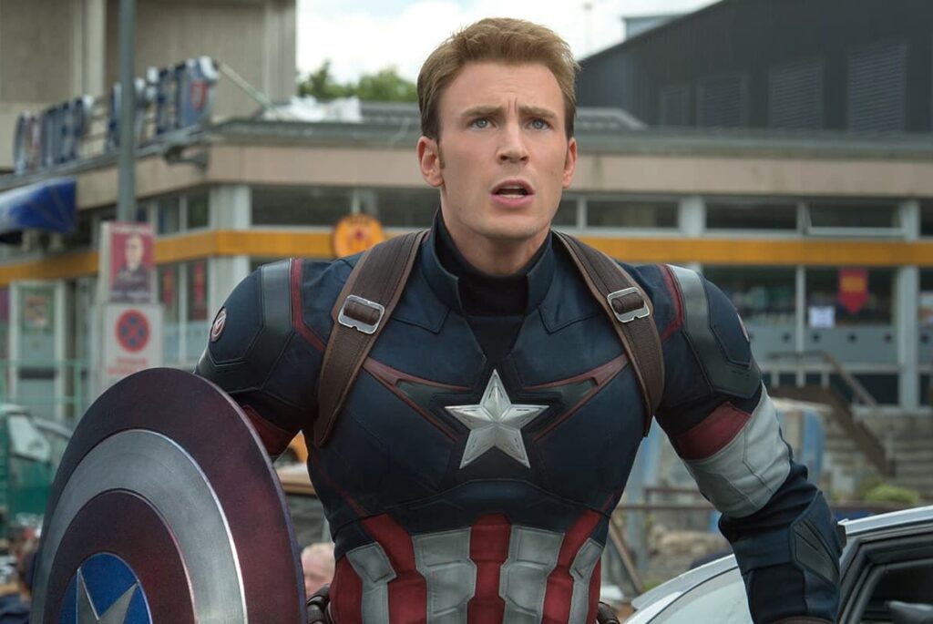 Chris Evans terlihat mengendarai sepeda motor di jalan pedesaan, memasuki rumah bergaya klasik, lalu menyimpan kostum Captain America sebelum menggendong seorang bayi yang sedang tidur.